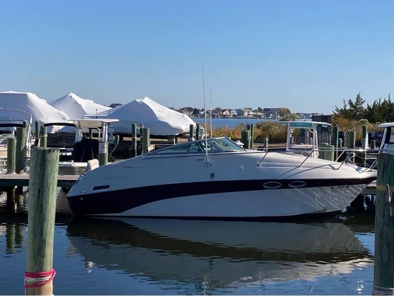 Slide: The Image of 2000 Crownline 268 boat docked at a marina with covered boats in the background. - 3