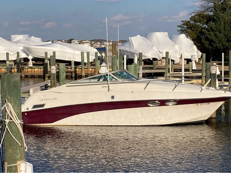 Slide: The Image of 2000 Crownline 268 boat docked at a marina with covered boats in the background. - 6