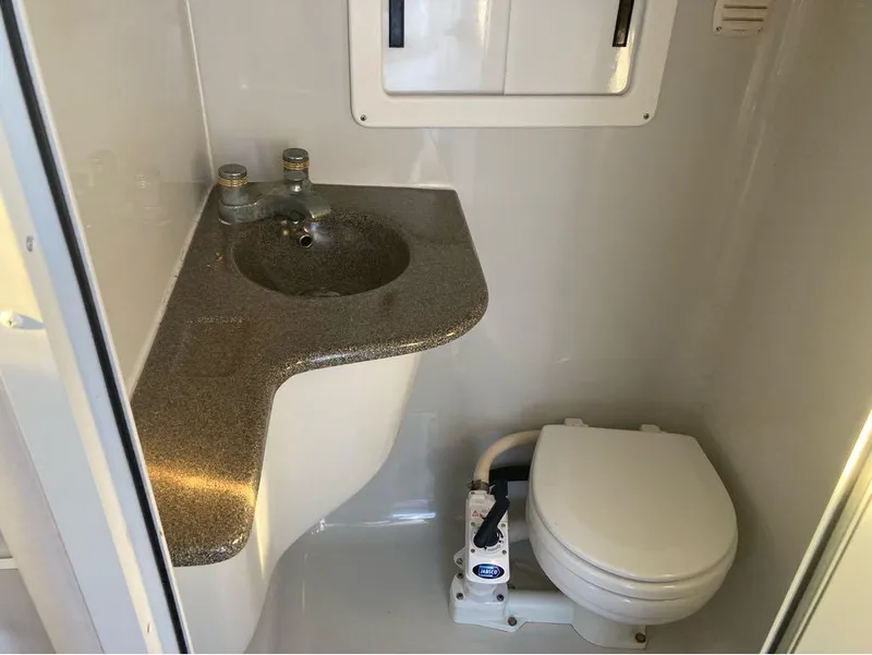 Slide: The Image of Compact bathroom in a 2000 Crownline 268 boat with sink and marine toilet. - 9