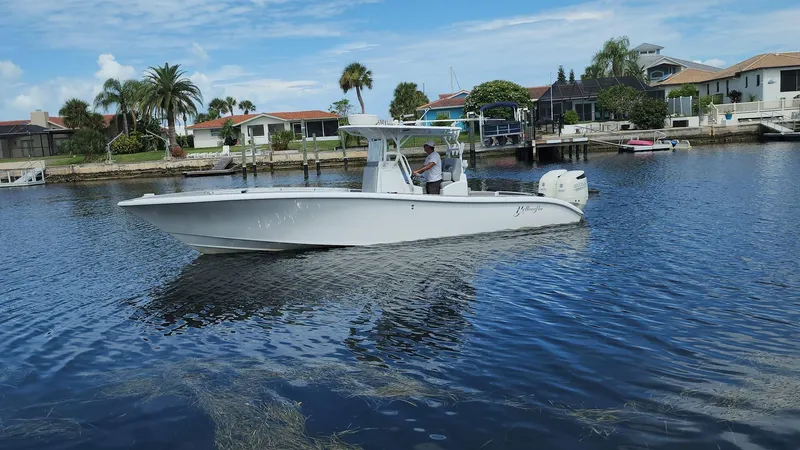 Slide: The Image of 2005 Yellowfin 31 boat cruising on a calm waterway near residential area. - 0