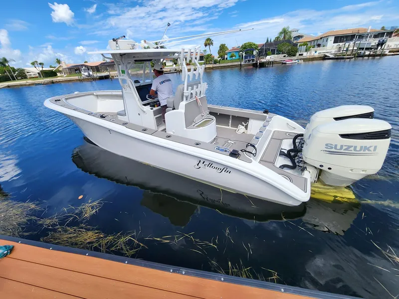 Slide: The Image of 2005 Yellowfin 31 boat with Suzuki engine on a calm waterfront. - 1