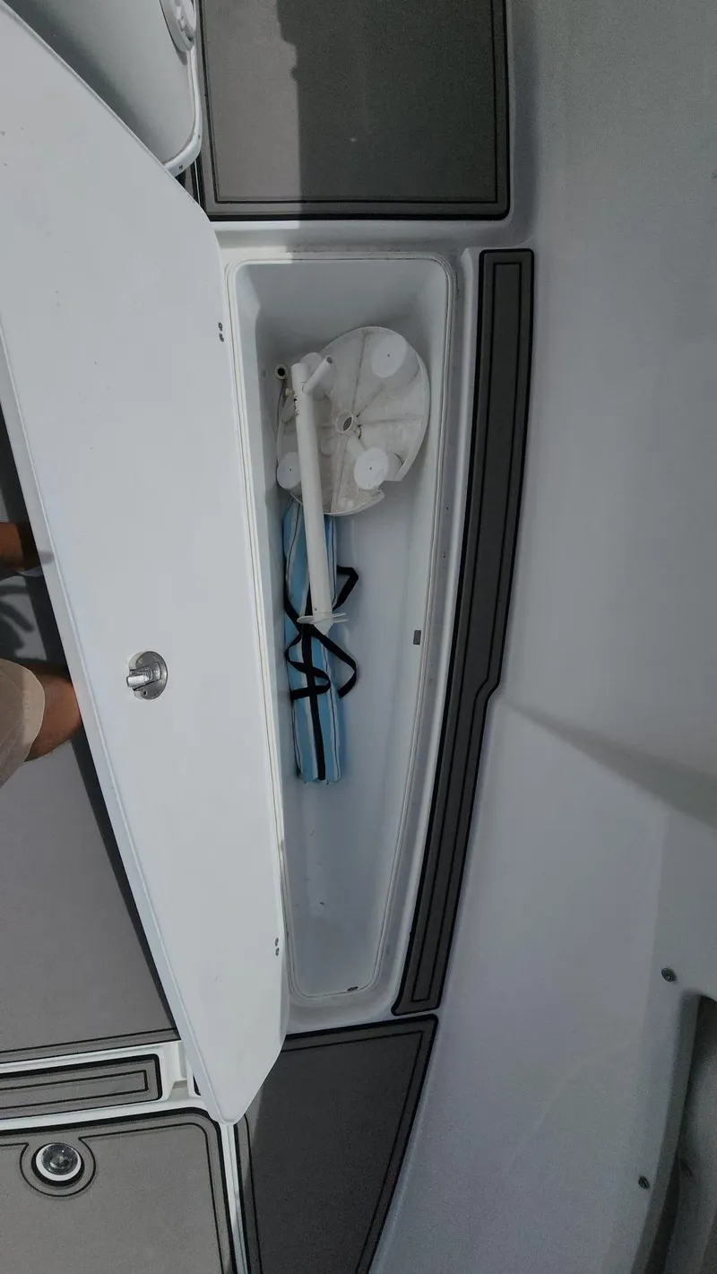 Slide: The Image of Open storage compartment on 2005 Yellowfin 31 boat with various items inside. - 13