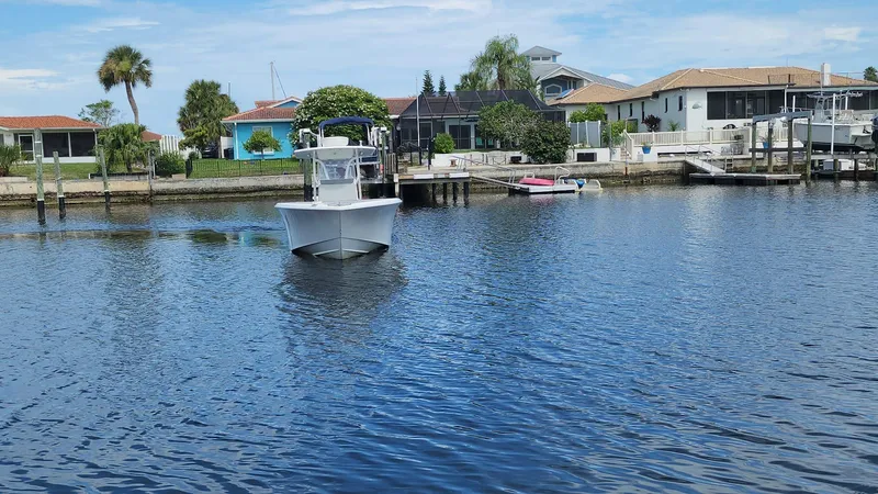 Slide: The Image of 2005 Yellowfin 31 boat on calm water near residential docks. - 14