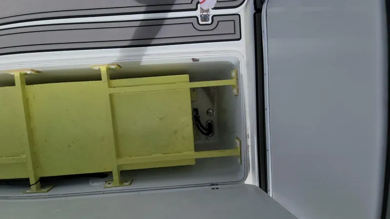 Slide: The Image of 2005 Yellowfin 31 boat storage compartment with yellow divider. - 36