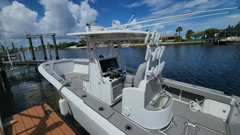 Slide: The Image of 2005 Yellowfin 31 boat docked by a scenic waterfront under a blue sky. - 38