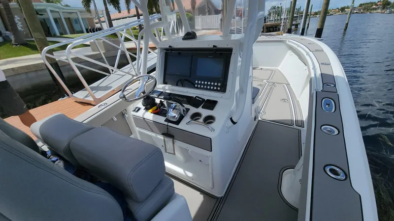 Slide: The Image of 2005 Yellowfin 31 boat interior with modern console and seating, docked by the water. - 4