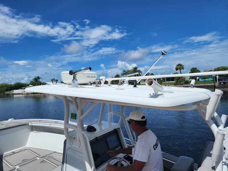 Slide: The Image of 2005 Yellowfin 31 boat with radar, man at helm, clear sky, calm water. - 46