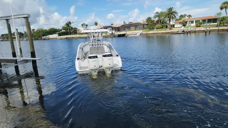 Slide: The Image of 2005 Yellowfin 31 boat on a calm waterfront with palm trees. - 47