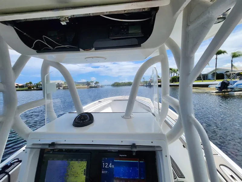 Slide: The Image of 2005 Yellowfin 31 boat dashboard with navigation equipment on a calm waterway. - 48