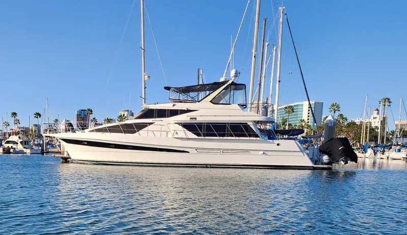 Slide: The Image of 1999 McKinna 57 Pilothouse yacht docked in a marina under clear blue skies. - 1