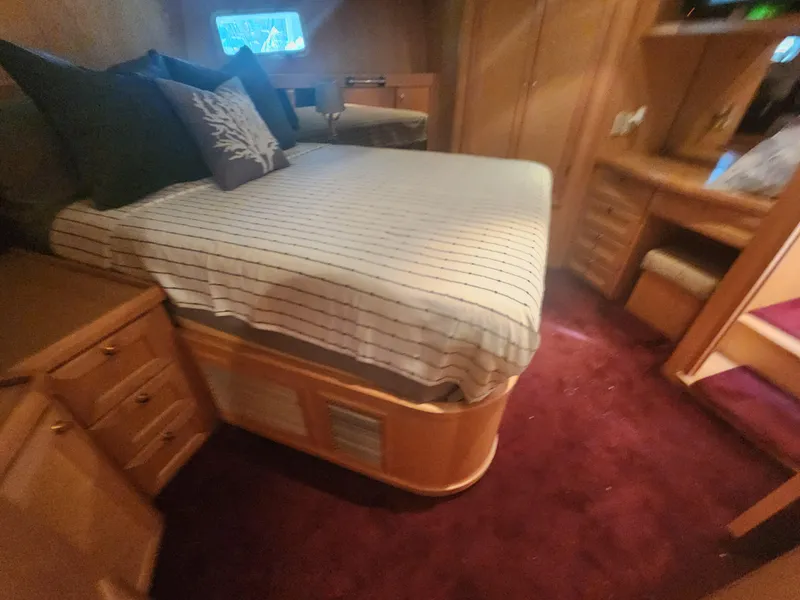 Slide: The Image of Cozy bedroom interior of 1999 McKinna 57 Pilothouse yacht with striped bedding and wooden furnishings. - 17