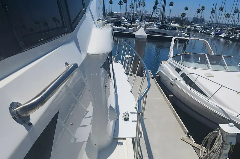 Slide: The Image of 1999 McKinna 57 Pilothouse yacht docked in a marina with other boats. - 21