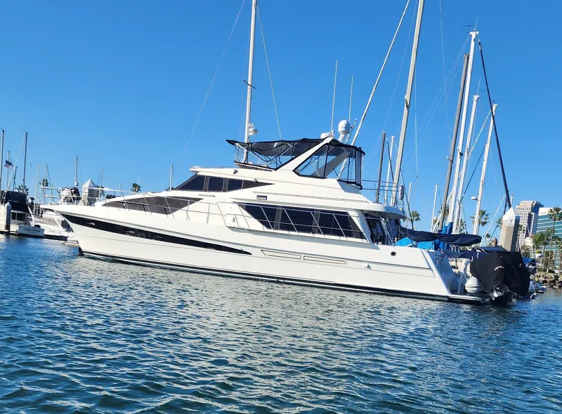 Slide: The Image of 1999 McKinna 57 Pilothouse yacht docked in a marina under clear blue skies. - 23