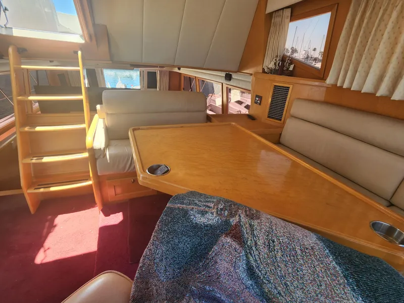 Slide: The Image of Interior of 1999 McKinna 57 Pilothouse yacht with wooden table and seating. - 24
