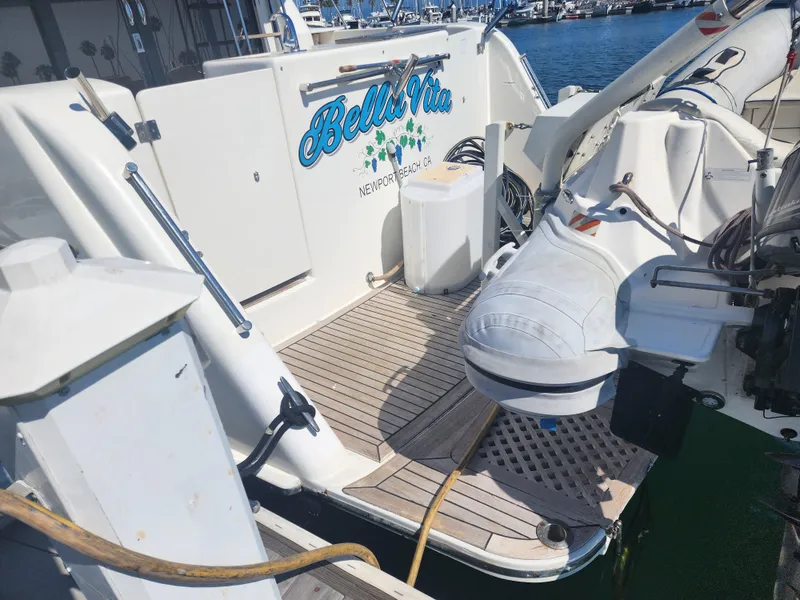 Slide: The Image of 1999 McKinna 57 Pilothouse yacht docked, featuring a small boat and deck equipment. - 26