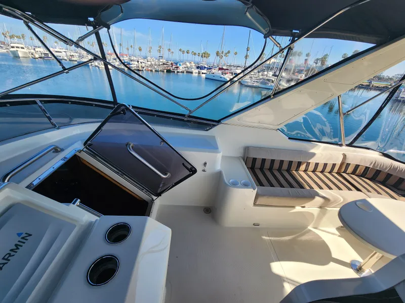 Slide: The Image of 1999 McKinna 57 Pilothouse interior with seating, marina view, and Garmin equipment. - 30