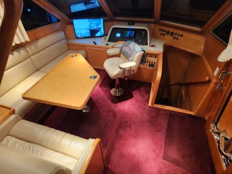 Slide: The Image of 1999 McKinna 57 Pilothouse interior with plush seating, control panel, and rich wood accents. - 34