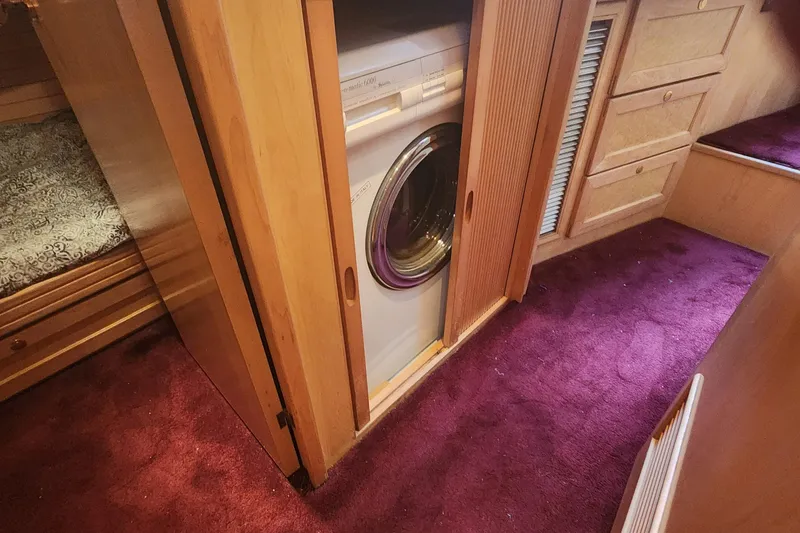 Slide: The Image of Laundry area in 1999 McKinna 57 Pilothouse with purple carpet and wooden cabinetry. - 7