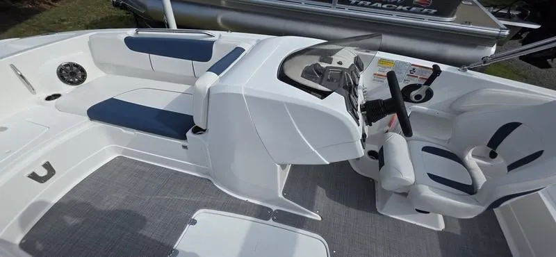 Slide: The Image of 2024 Tahoe 2150 boat interior with white and blue seating, steering console, and modern design. - 18