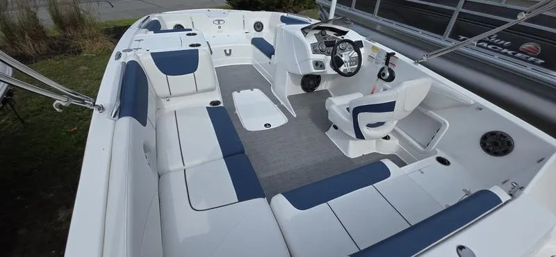 Slide: The Image of 2024 Tahoe 2150 boat interior with blue and white seating, steering console, and spacious layout. - 5