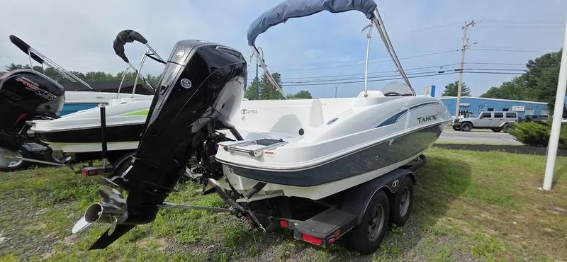 Slide: The Image of 2024 Tahoe 2150 boat on trailer, outboard motor, parked on grass. - 7