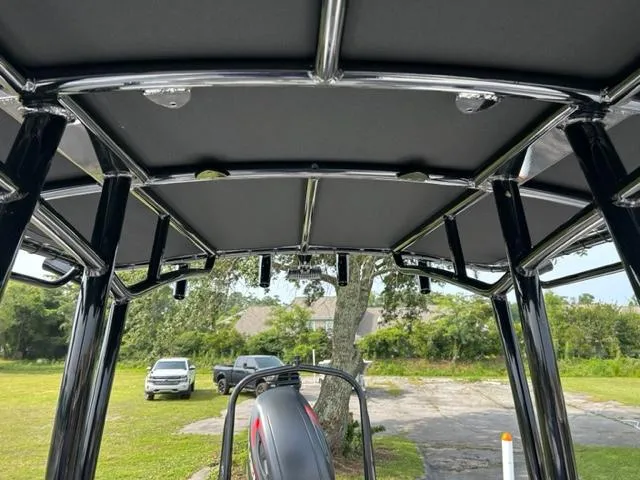 Slide: The Image of 2024 Savannah SS21 boat with T-top frame and canopy, parked outdoors. - 22