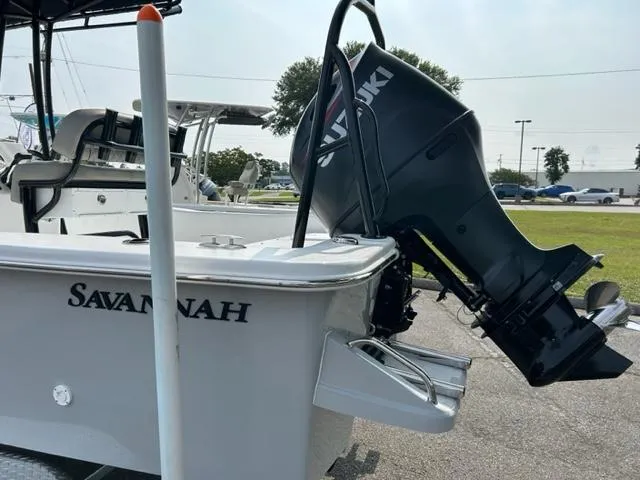 Slide: The Image of 2024 Savannah SS21 boat with Suzuki outboard motor in a marina. - 6