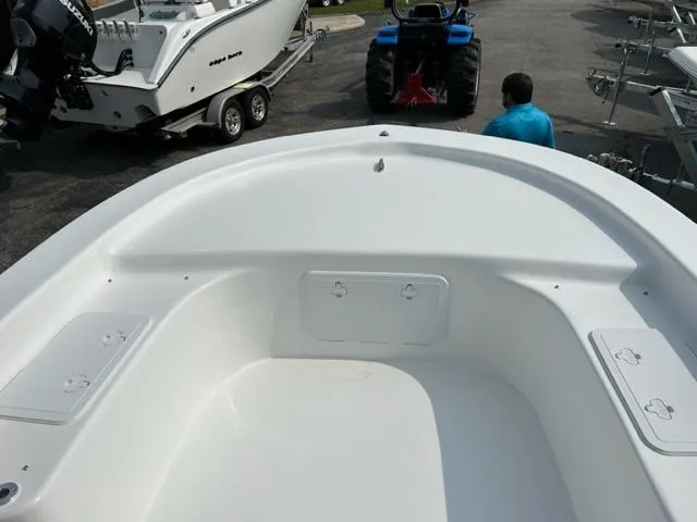 Slide: The Image of 2024 Savannah SS21 boat interior with storage compartments, docked near other boats and a tractor. - 14