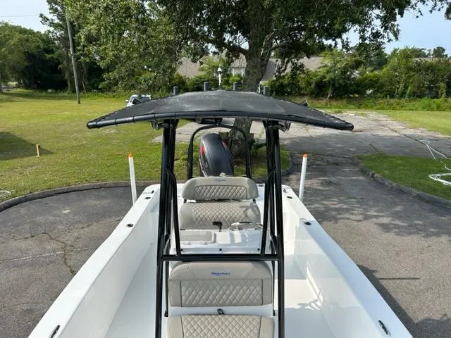 Slide: The Image of 2024 Savannah SS21 boat with T-top and seating, parked on a driveway. - 16