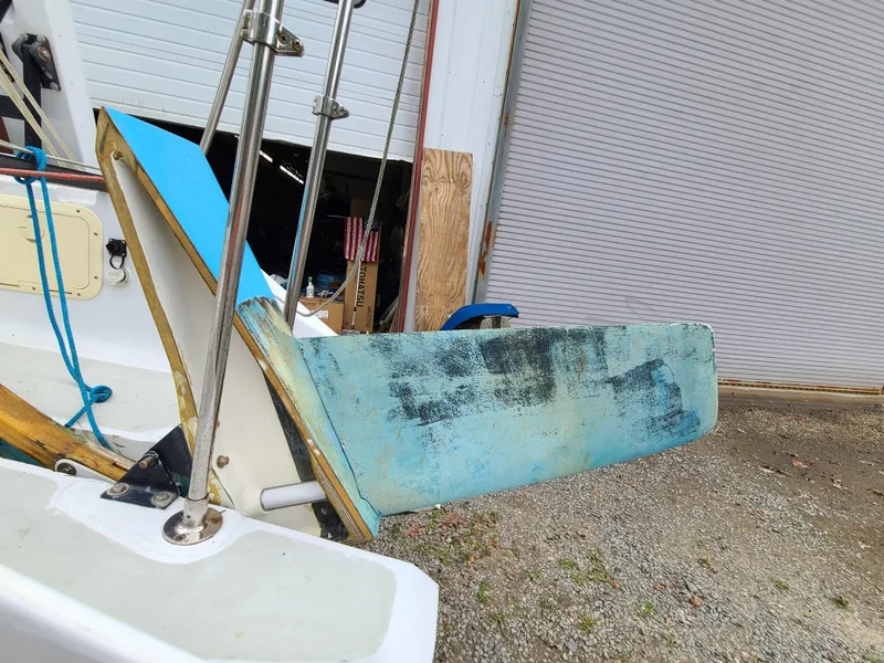 Slide: The Image of Farrier F-25C #22 sailboat rudder, 2016 model, with visible wear, in a storage area. - 17
