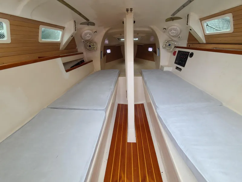 Slide: The Image of Interior of 2016 Farrier F-25C #22 sailboat with twin cushioned benches and wooden flooring. - 9
