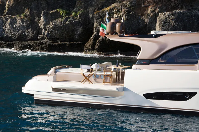 Slide: The Image of 2024 Solaris 57 Lobster yacht near rocky coastline, featuring elegant deck seating. - 7