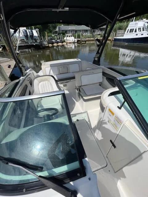 Slide: The Image of 2013 Sea Ray 240 Sundeck boat interior with seating and steering wheel. - 16