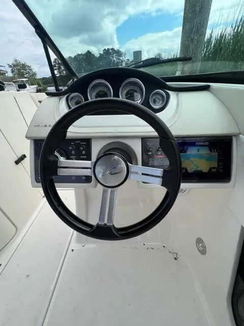 Slide: The Image of 2013 Sea Ray 240 Sundeck boat dashboard with steering wheel and navigation display. - 17