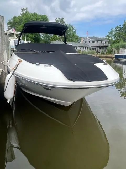 Slide: The Image of 2013 Sea Ray 240 Sundeck boat docked in a calm marina. - 2