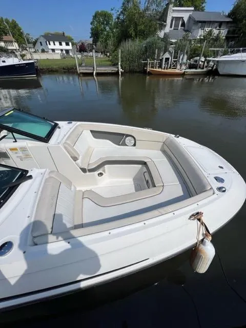 Slide: The Image of 2013 Sea Ray 240 Sundeck boat docked in a calm marina. - 6
