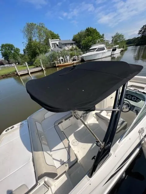 Slide: The Image of 2013 Sea Ray 240 Sundeck boat docked by a serene waterfront. - 8