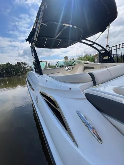 Slide: The Image of 2013 Sea Ray 240 Sundeck boat docked on a calm lake. - 9