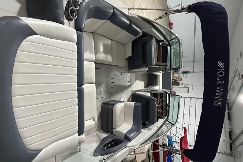 Slide: The Image of 2008 Four Winns 262 boat interior with white and gray seating, under a blue canopy. - 16
