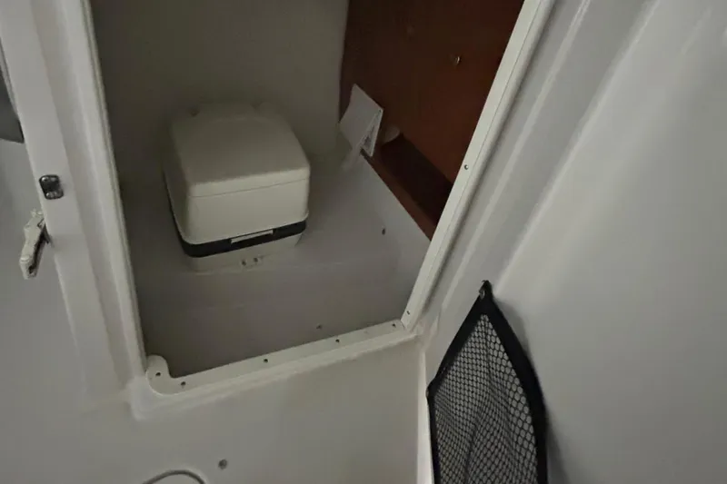 Slide: The Image of 2008 Four Winns 262 boat interior with compact toilet and storage. - 8