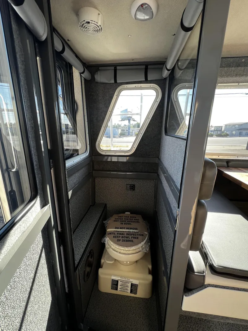 Slide: The Image of 2023 Thunder Jet 26 Pilot boat interior with compact toilet and seating area. - 13