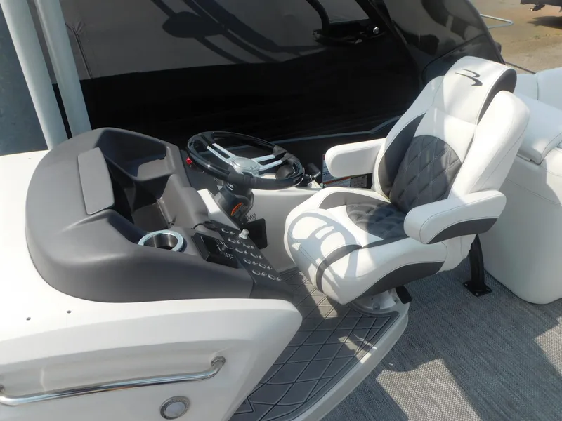 Slide: The Image of 2024 Bennington 23 RFBA helm with luxurious captain's chair and modern controls. - 8