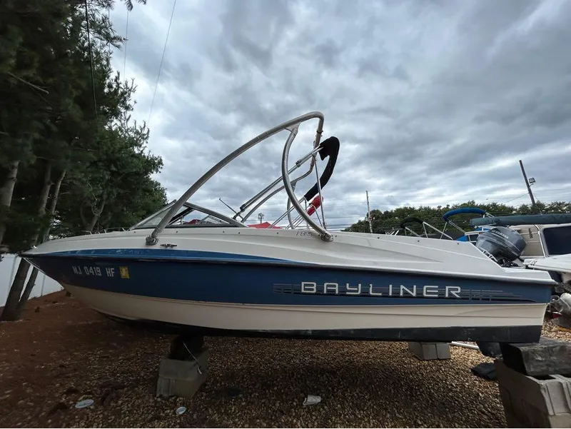 The Image of 2013 Bayliner 185 boat on dry dock under cloudy sky. - 1