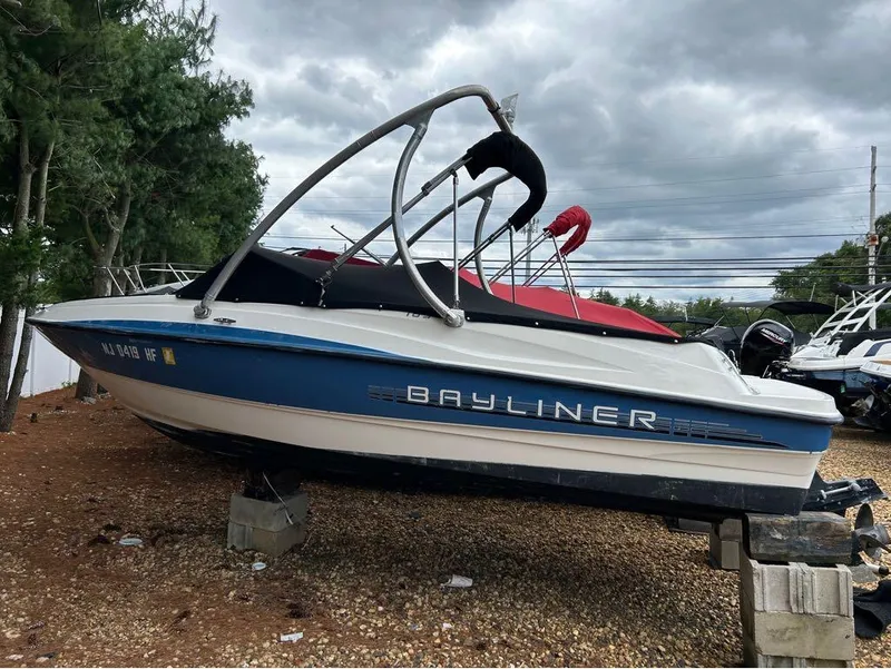 Slide: The Image of 2013 Bayliner 185 boat on blocks, blue and white, with a red cover. - 10