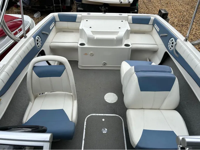 Slide: The Image of 2013 Bayliner 185 boat interior with blue and white seating. - 2