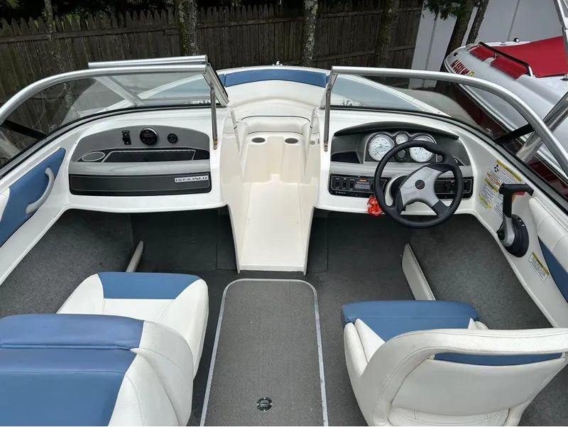 Slide: The Image of 2013 Bayliner 185 boat interior with steering wheel, dashboard, and seating. - 6