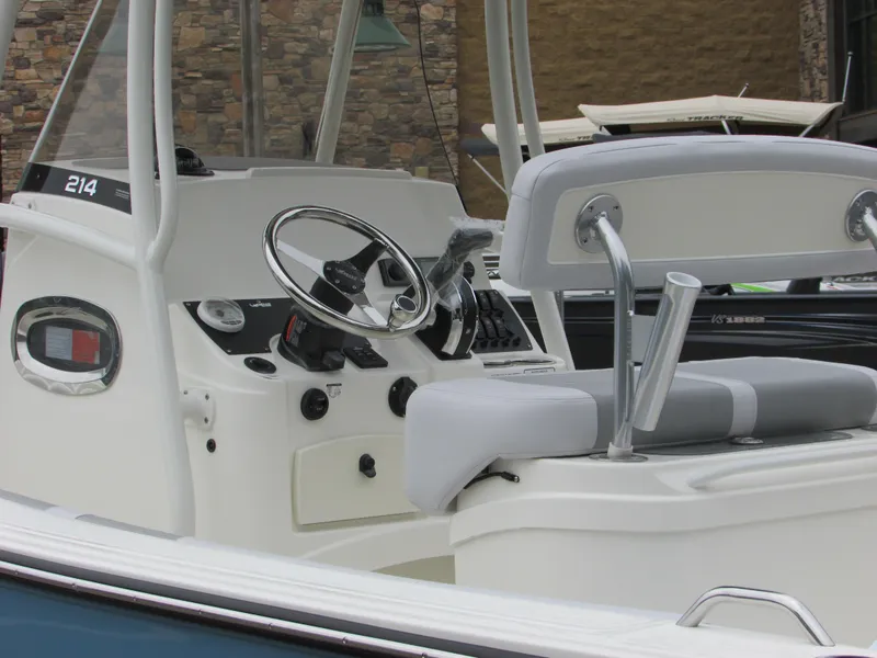 Slide: The Image of 2023 Mako 214 CC boat interior with steering wheel and seating. - 7