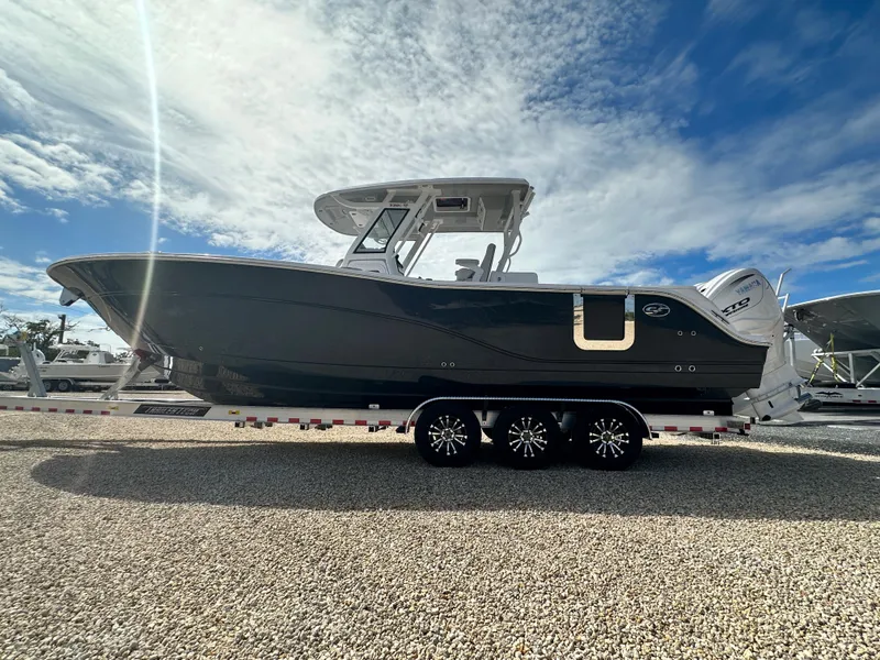 Slide: The Image of 2024 Sea Fox 328 Commander boat on trailer under a bright blue sky. - 13