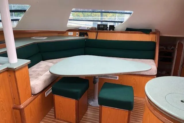 Slide: The Image of Interior of 2005 Manta 42 MK II yacht with green cushioned seating and wooden accents. - 9