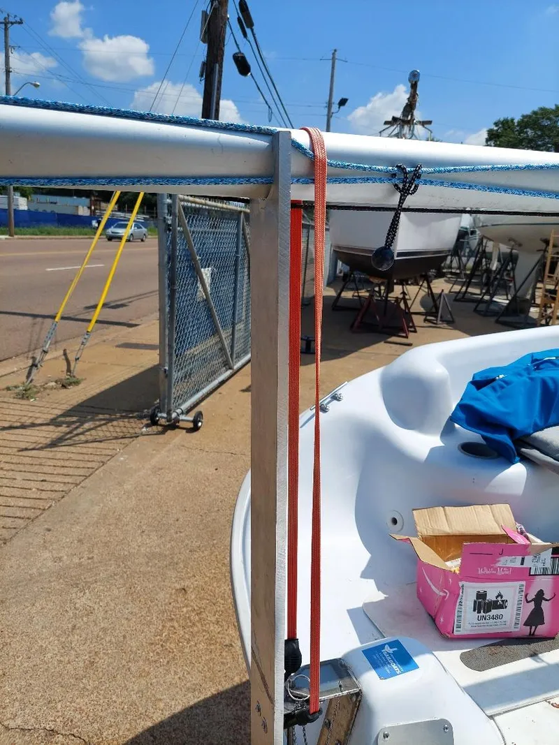 Slide: The Image of 1998 Hunter 170 sailboat with rigging, docked outdoors under a clear blue sky. - 12